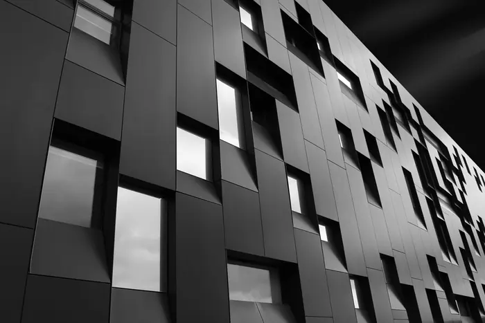 Façade contemporaine sombre aux fenêtres irrégulières