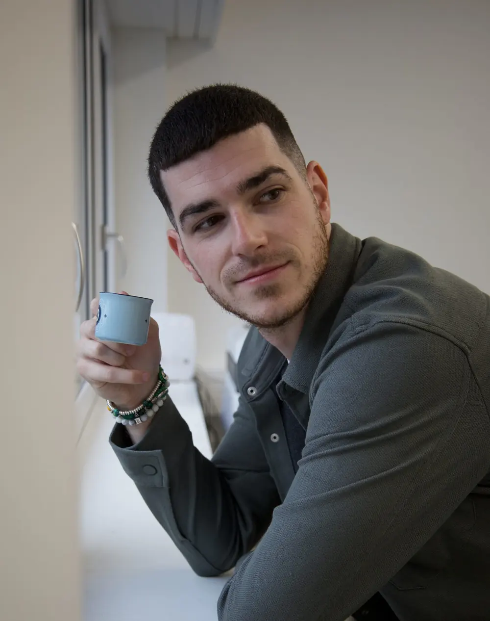 David Giannarelli, une tasse à la main, près de la fenêtre de son bureau