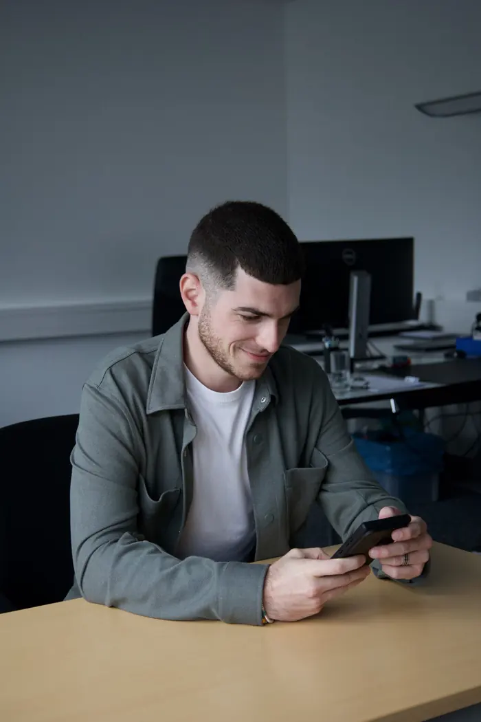 David Giannarelli consultant son téléphone à son bureau