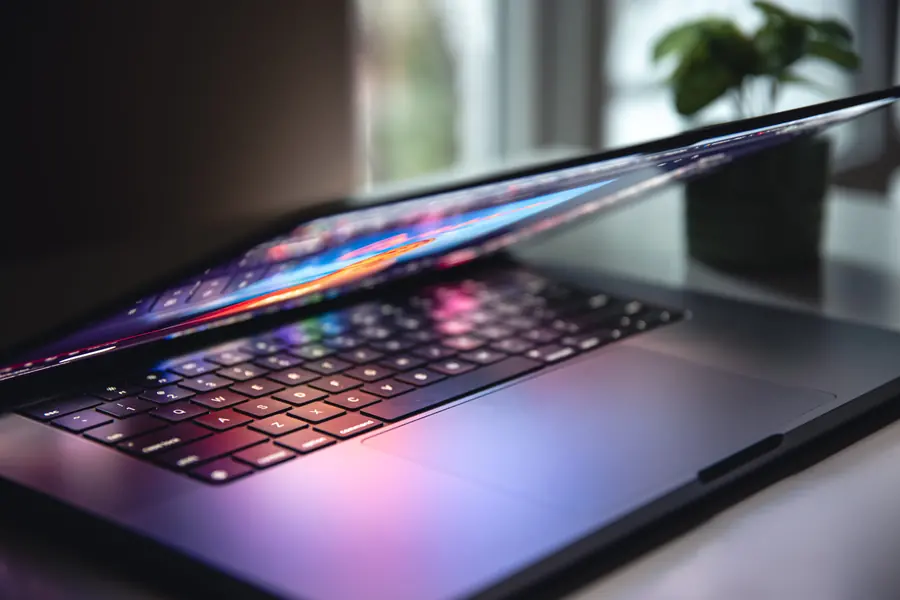 Ordinateur portable entrouvert, clavier éclairé par l’écran — maintenance de sites WordPress à Verbier