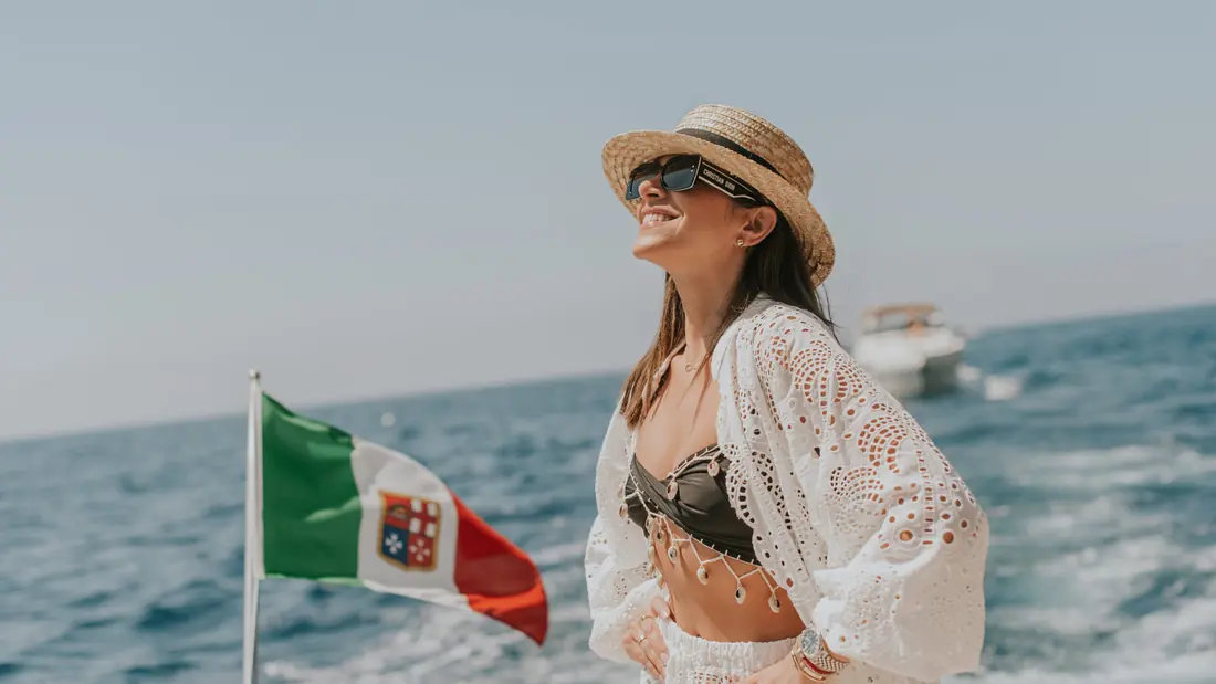 Passagère à l’arrière d’un bateau, drapeau italien au vent