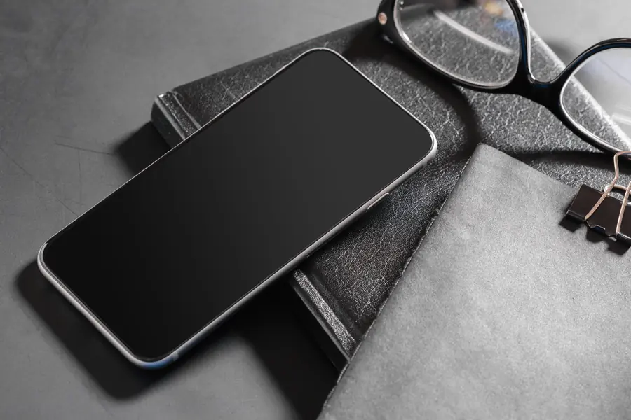 Smartphone posé sur des carnets — solutions web et applications sur mesure à Verbier