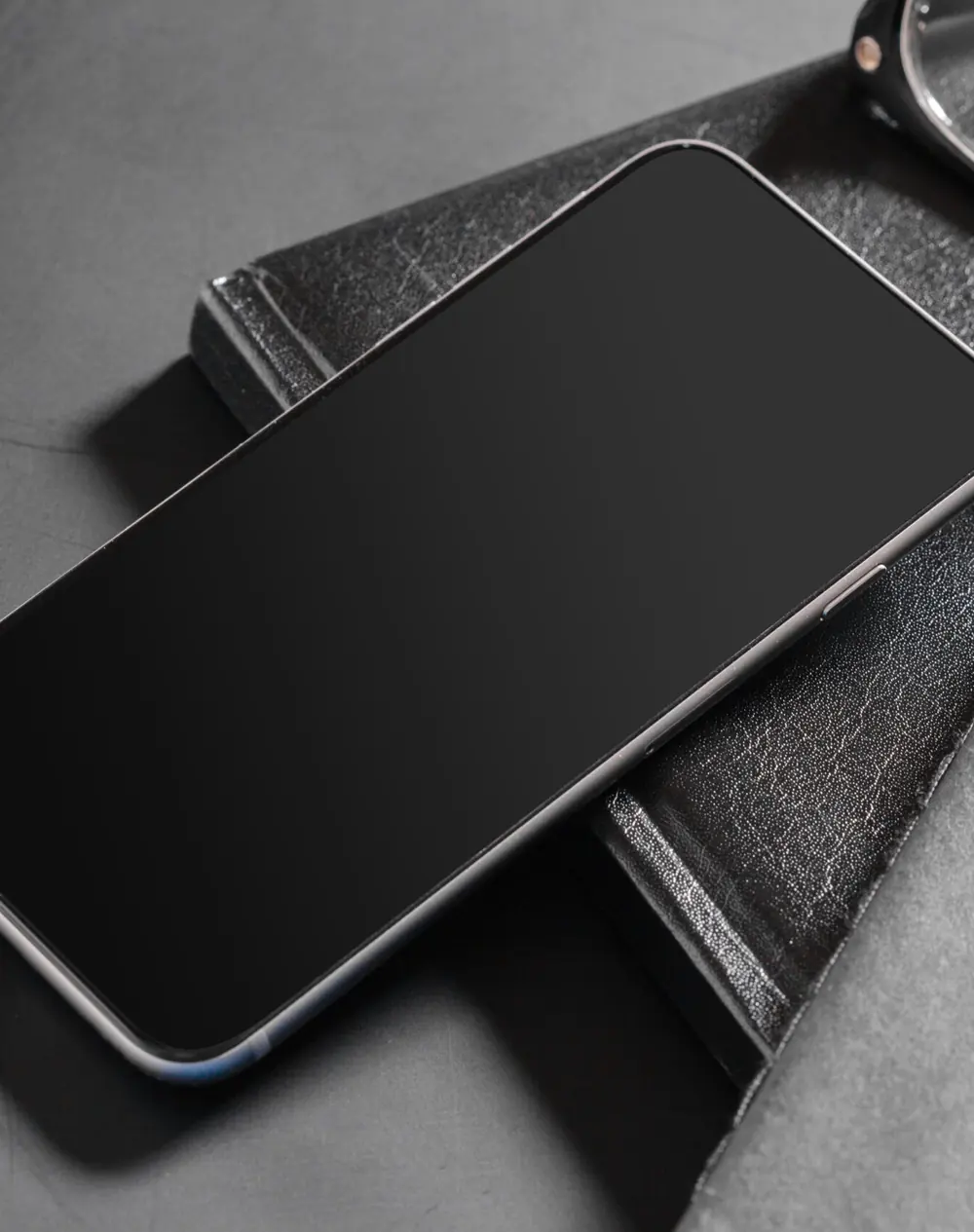 Smartphone posé sur des carnets — développement d’applications sur mesure pour Verbier